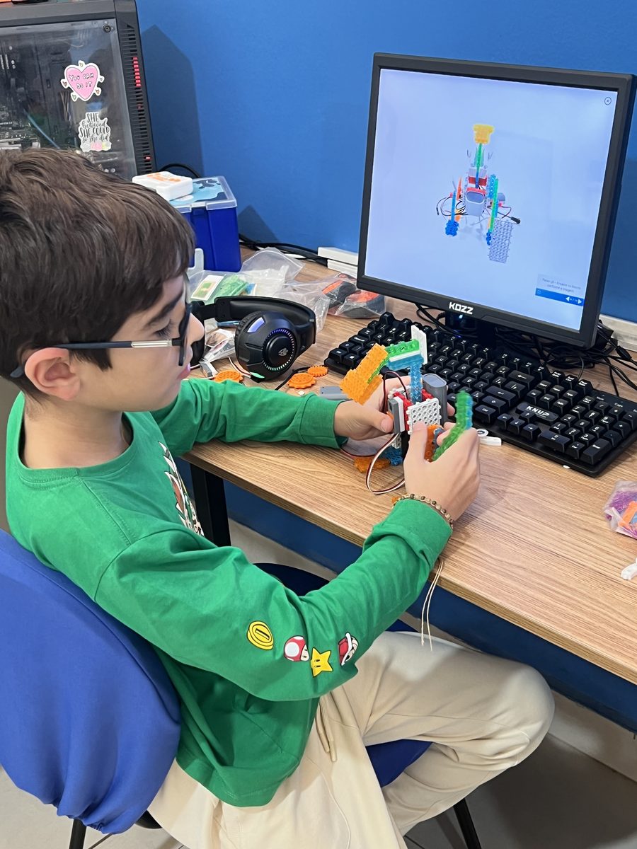 Aluno de 7 anos montando um robô com kit educacional