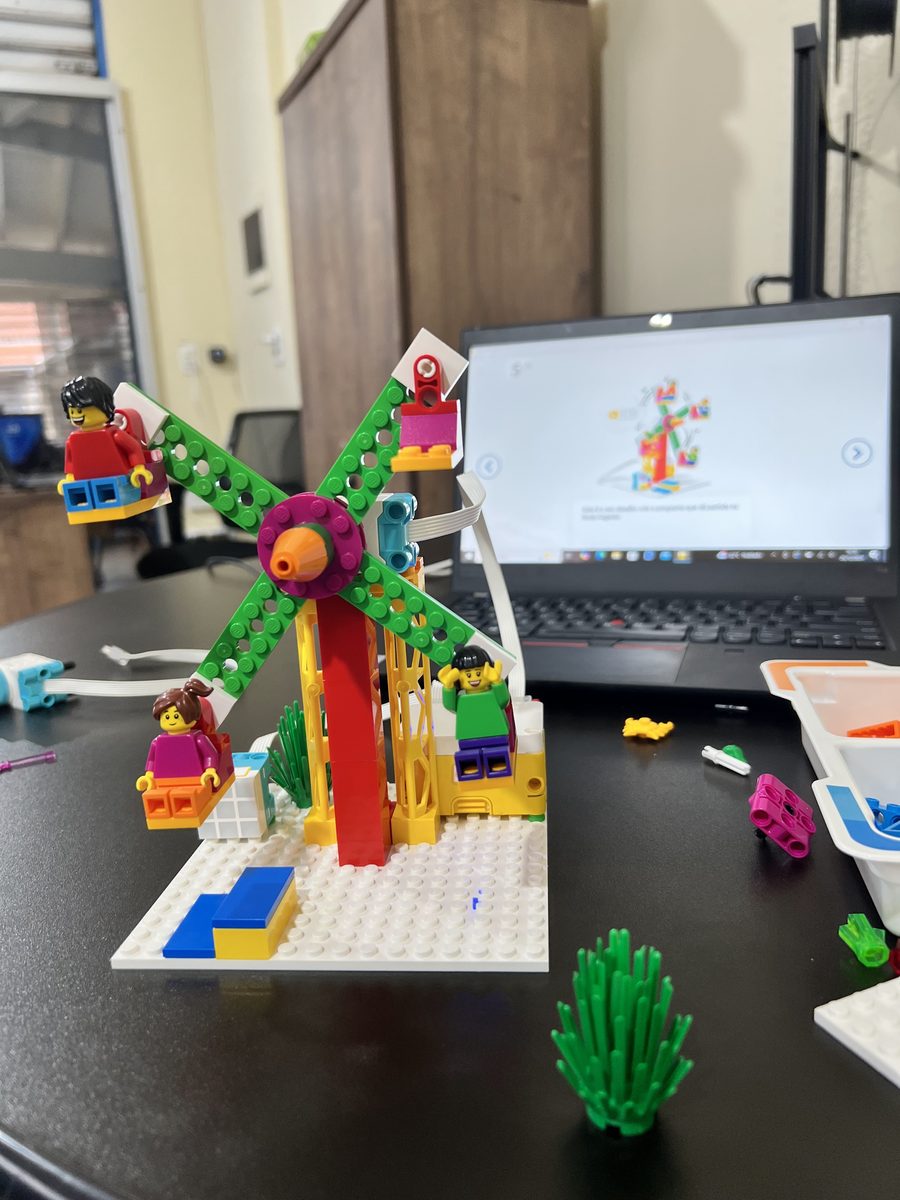 Criança montando projeto de robótica com peças Lego